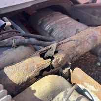 Severely rusted vehicle frame component before repair
